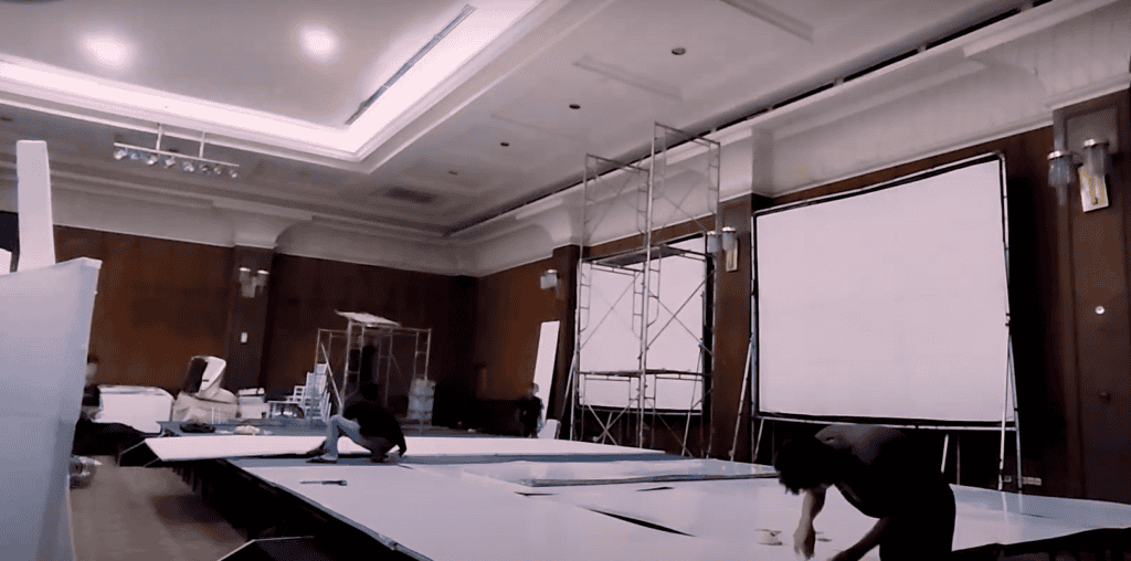 Team installing styrofoam panels on wedding stage at venue