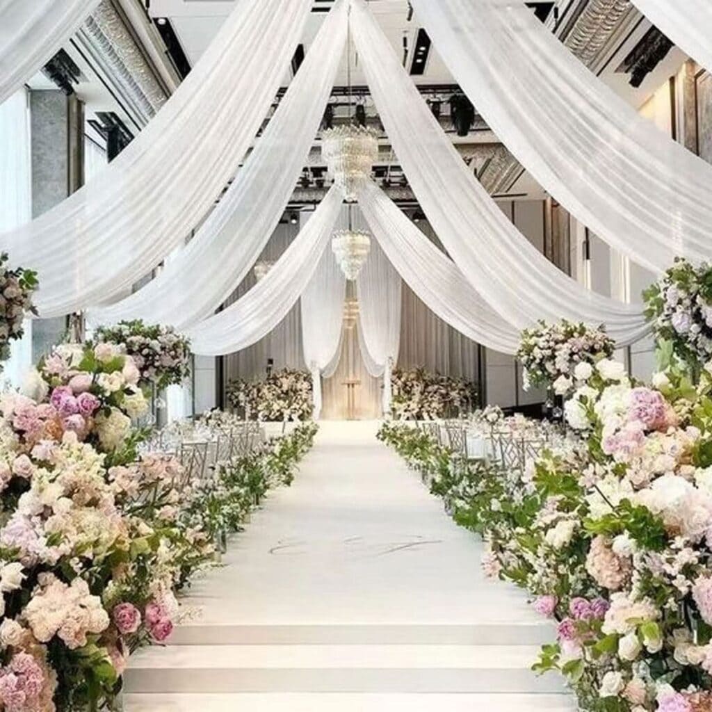 Aisle decor with flowing white drapery and floral accents