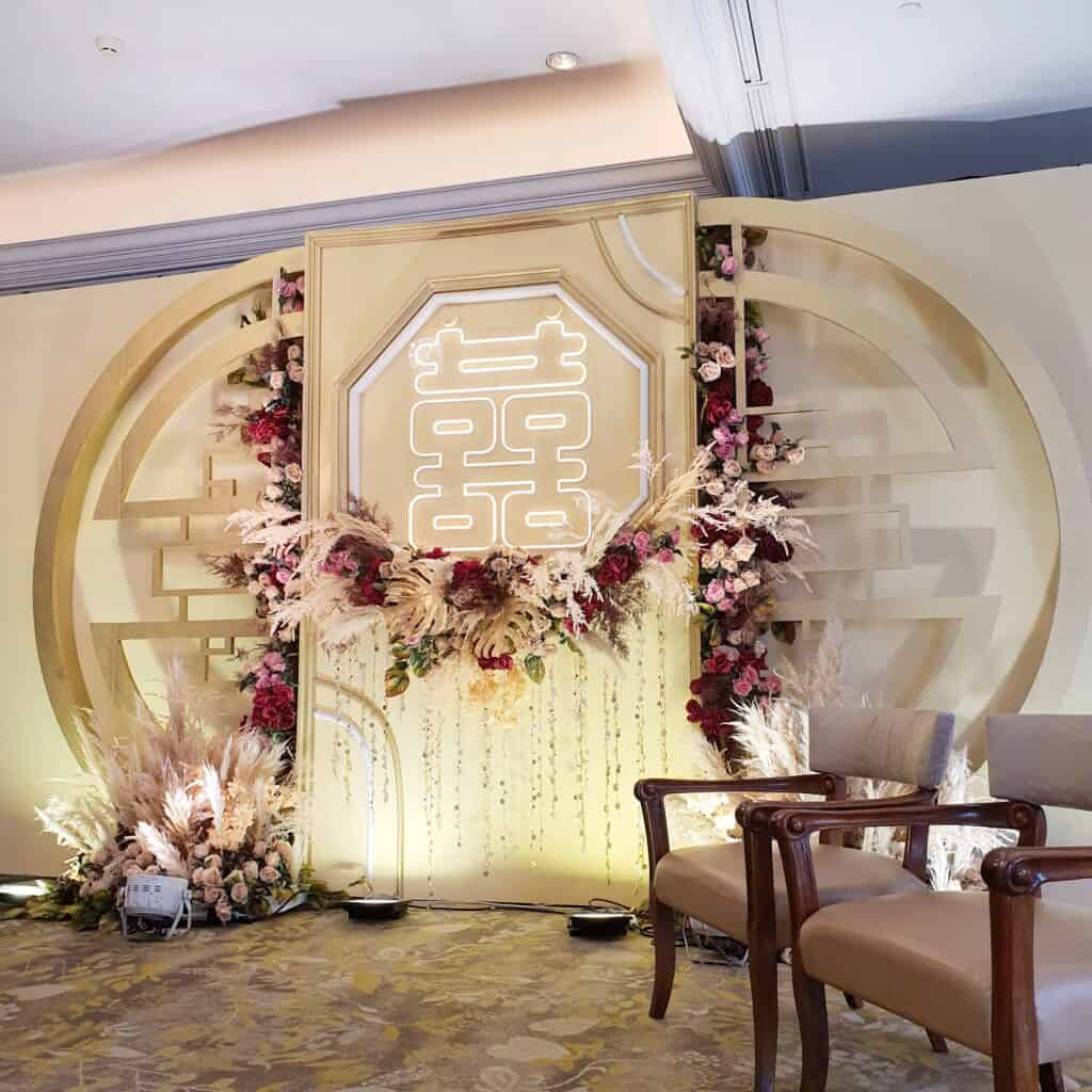 Trinity’s Chinese wedding backdrop featuring double happiness symbol and floral installation